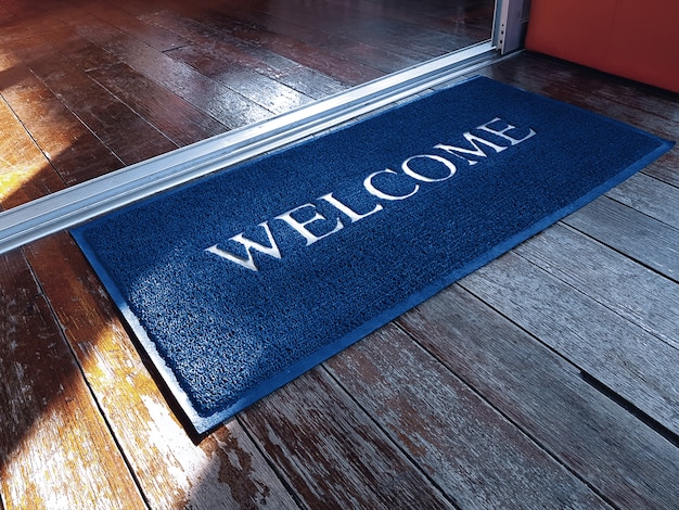 Blue Doormat with Welcome Text in Front of Shop