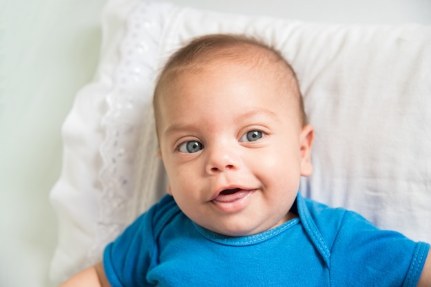 Blue eyed baby boy lying in crib