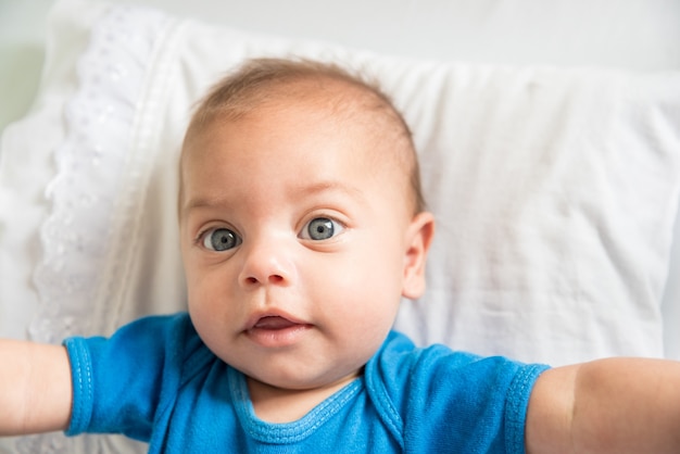 Blue eyed baby boy lying in crib 