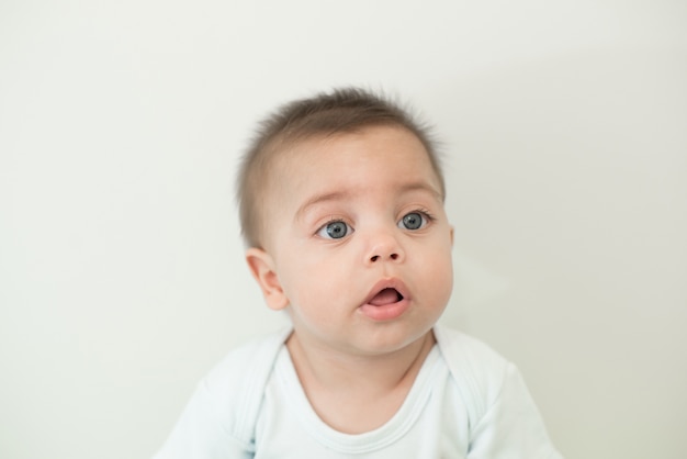 Blue-eyed baby boy on white background 