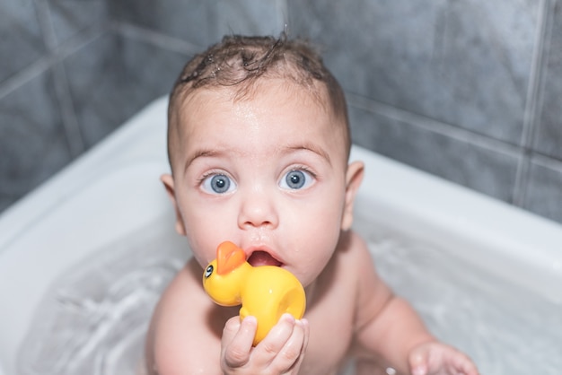 Blue-eyed boy bathing in bathtub