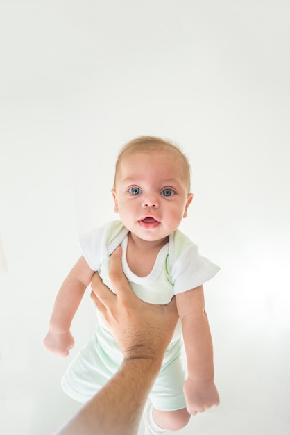 Blue eyes baby boy being lifted by father's arms