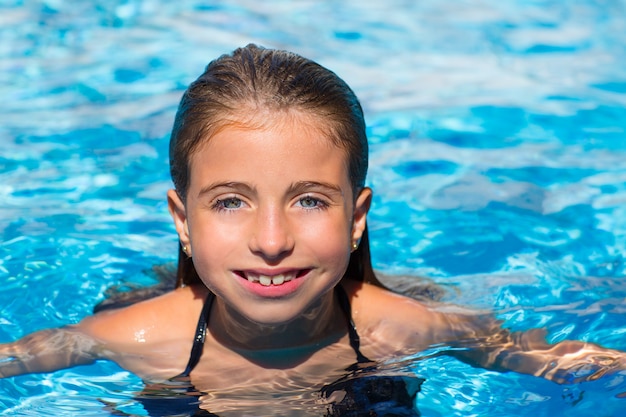 blue eyes kid girl at the pool face in water surface