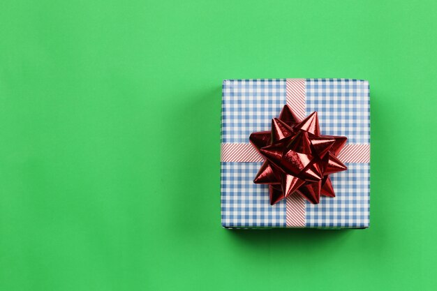 Photo blue gift box on green paper background and have copy space.