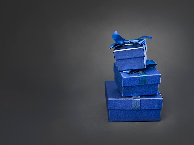 Photo blue gift boxes stand in a stack on a black background