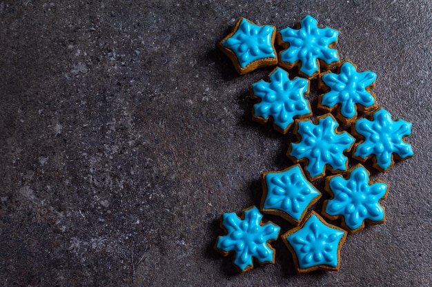 Blue gingerbread in the form of a snowflake on a gray background copy space