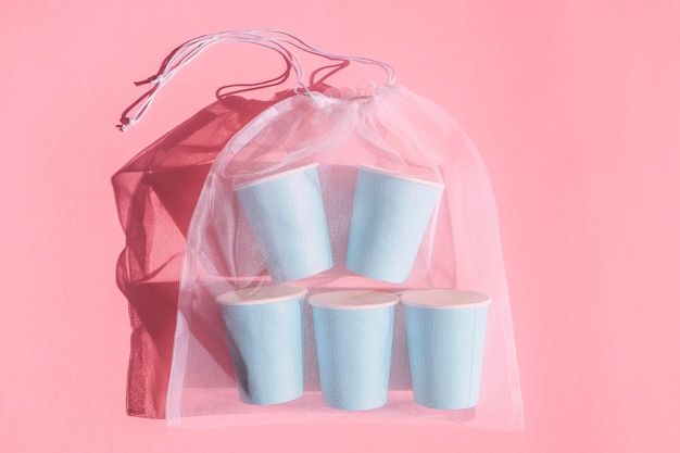 Blue glasses in a bag on pink