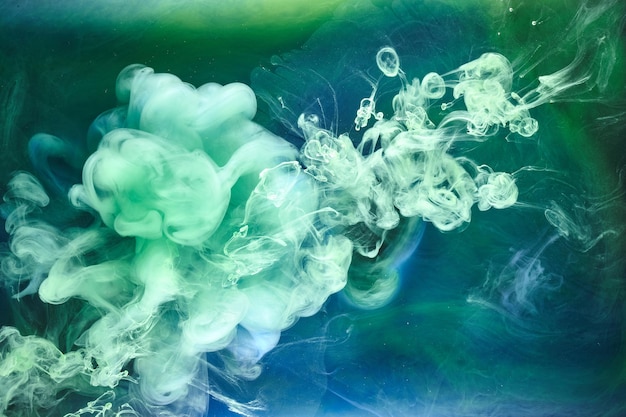 Blue green smoke on black ink background, colorful fog, abstract swirling ocean sea, acrylic paint pigment underwater