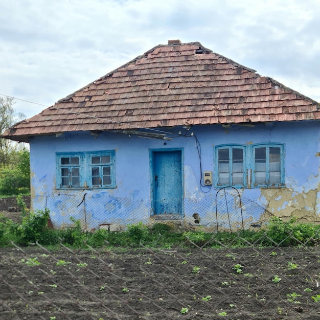 A blue house with a blue roof and a brown roof.