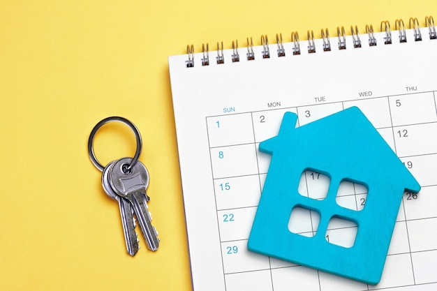 Blue house with calendar and keys on yellow background