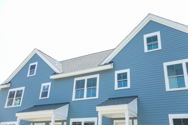 A blue house with a shingled roof