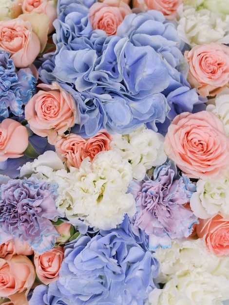 Blue hydrangeas beige roses white eustoma and unusual carnations are combined in a bouquet