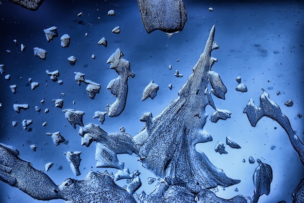 blue ice glass background, abstract texture of the surface of the ice on the glass, frozen seasonal water