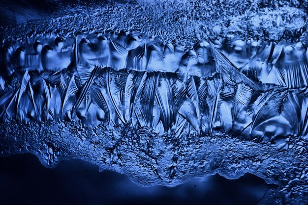 blue ice glass background, abstract texture of the surface of the ice on the glass, frozen seasonal water