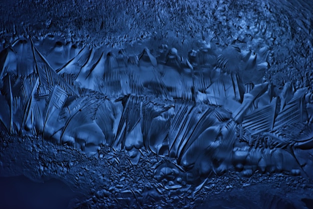 blue ice glass background, abstract texture of the surface of the ice on the glass, frozen seasonal water