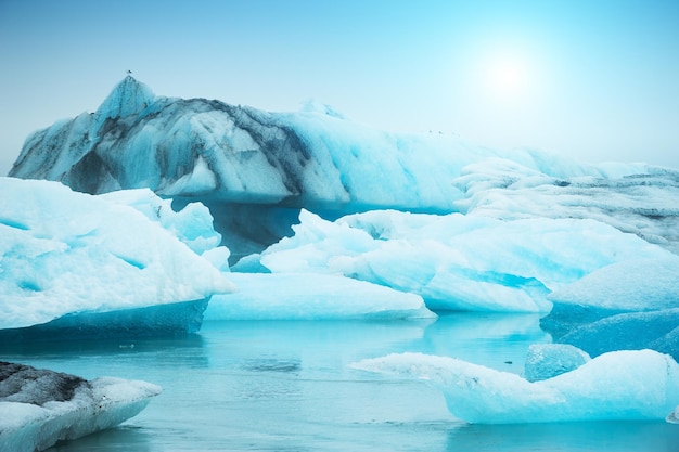 Blue icebergs in Jokulsarlon glacial lagoon at sunset, southern Iceland