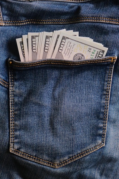 Blue jeans pocket with hundred dollars banknotes