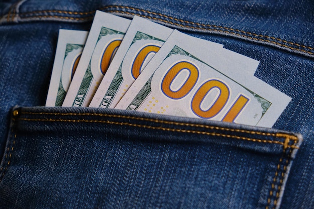 Blue jeans pocket with hundred dollars banknotes