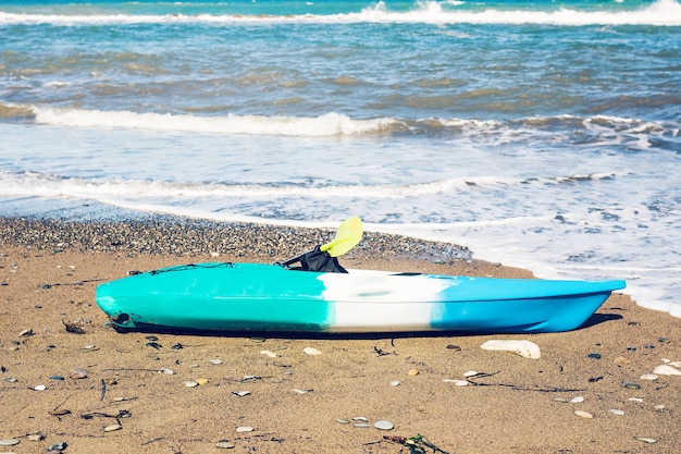 Blue kayak lying on the sandy beach