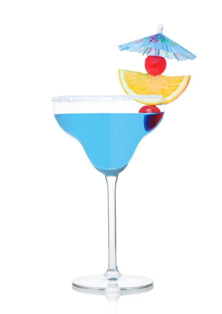 Blue lagoon summer cocktail in margarita glass with orange slice and sweet cherry with umbrella on white background.