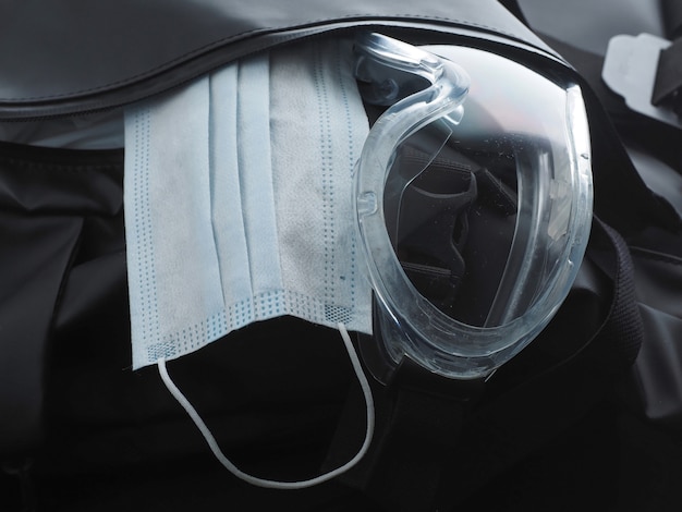 Blue Medical Mask and Protective Goggles in a black Backpack