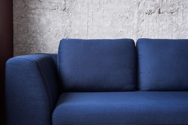 blue modern couch on concrete wall background