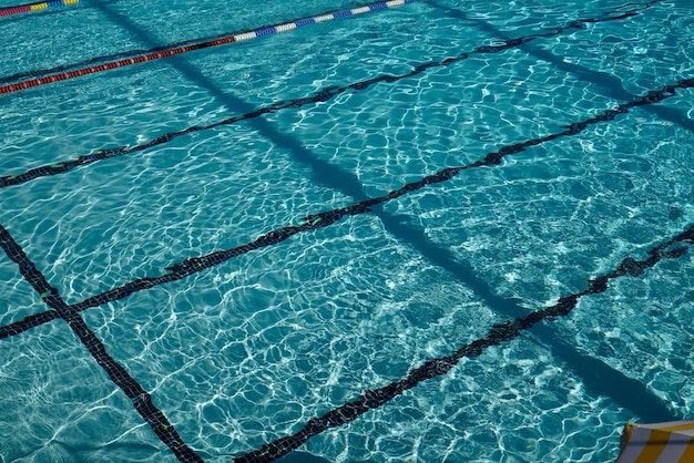 Blue mosaic tile background of public swimming pool water and swim line and umbrella