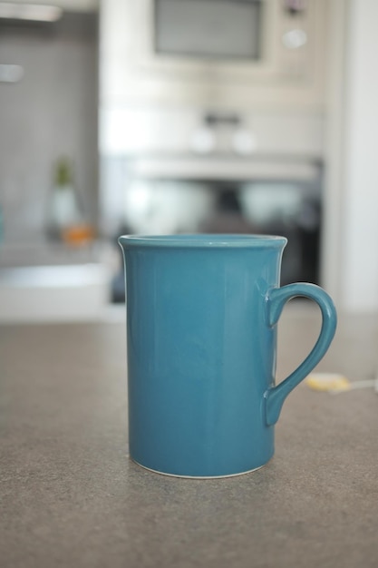 Blue mug on table with kitchen background