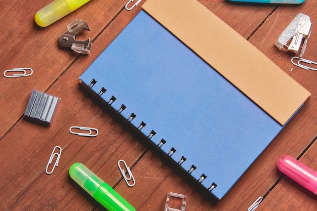 Blue notebook on wooden table with colored text brand