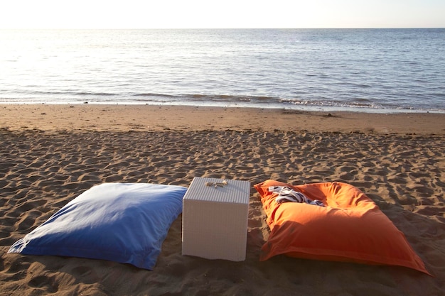 Blue and orange bean bags and table on the beach