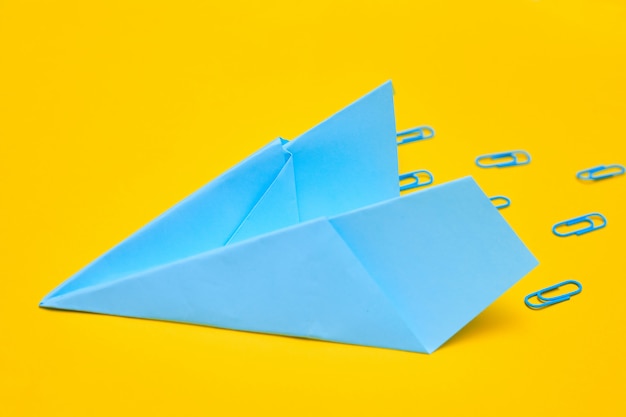 Blue paper airplane on a yellow background