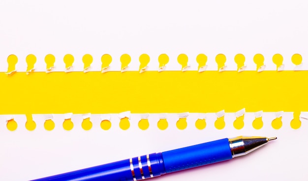 Blue pen and white torn paper strips on a bright yellow background with copy space for text or illustration. Template