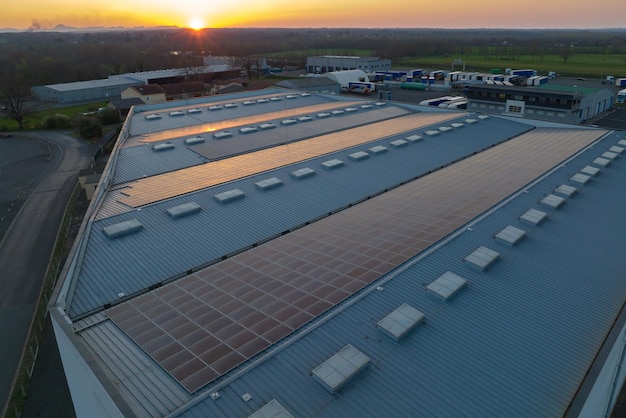 Blue photovoltaic solar panels mounted on building roof for producing clean ecological electricity at sunset Production of renewable energy concept