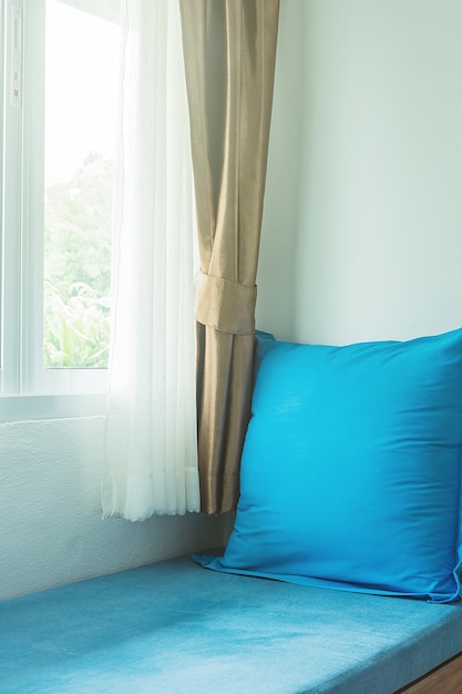 blue pillow near in glass window with soft light in the morning