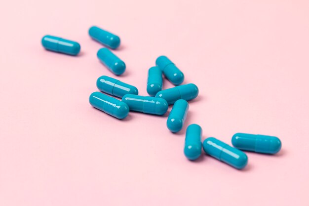 Blue pills on pink table