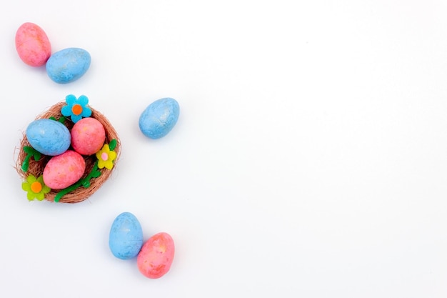 Blue and pink Easter eggs in a nest on a white background Flat lay Copy space