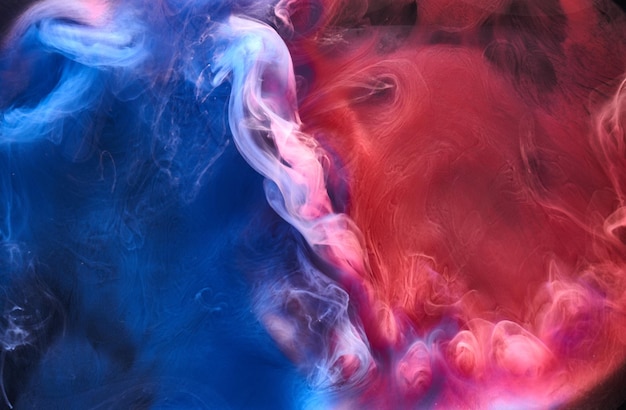 Blue pink smoke on black ink background, colorful fog, abstract swirling ocean sea, acrylic paint pigment underwater