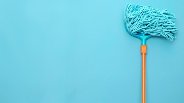 Photo blue plastic handle mop on light blue background