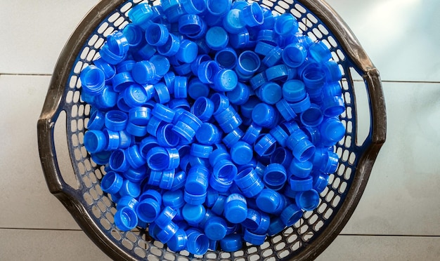 Blue plastic water bottle cap Lots of piles together in a plastic basket in drink water factory