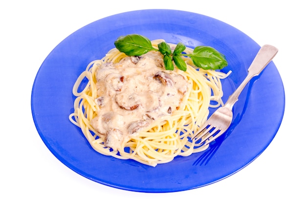 Blue plate with spaghetti and mushroom sauce.