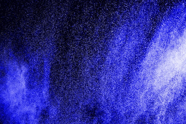 Blue powder splattered on black background.