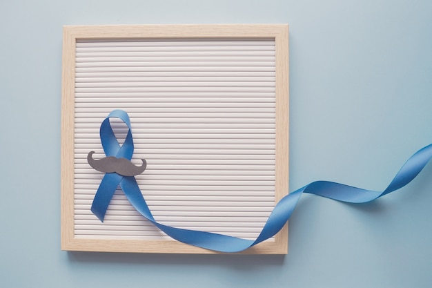 Blue ribbon with mustache on letter board, Prostate Cancer Awareness, Men health awareness