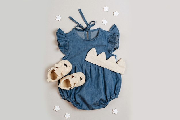 Blue romper with cotton crown and baby shoes. Cute set of baby clothes  