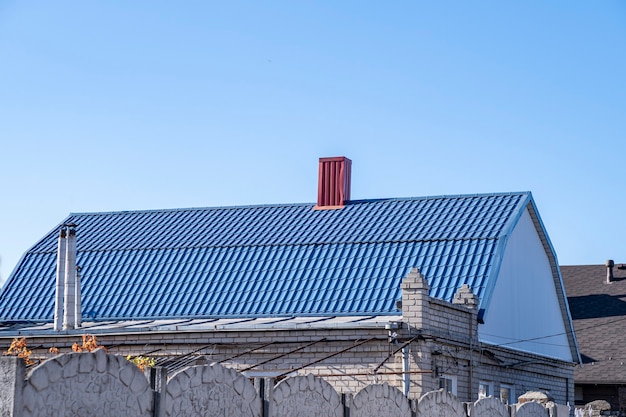 Blue roof with metal tiles  and red chimney.