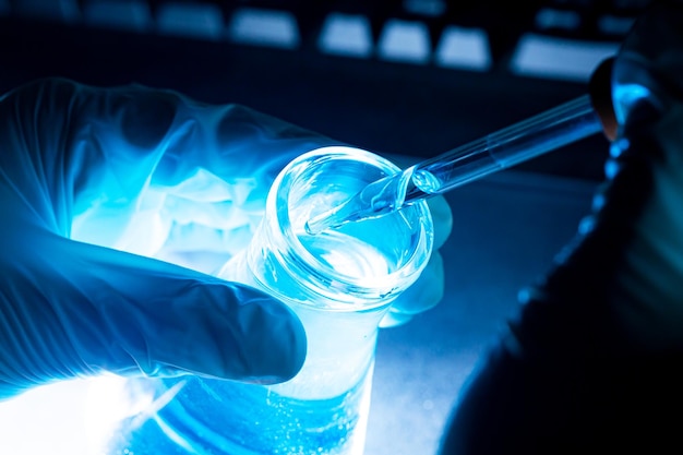 Blue science experiment glass tube,Researchers with chemistry test tubes in a liquid glass lab for