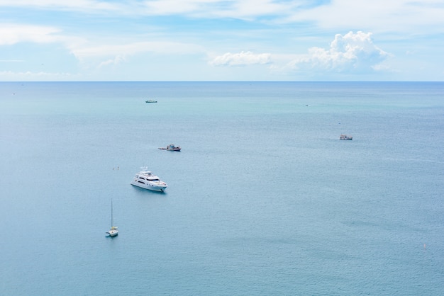 blue sea and cloudy sky over it and yacht boat