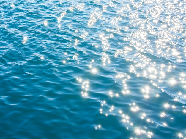 Blue sea water background with ripples and sunshine