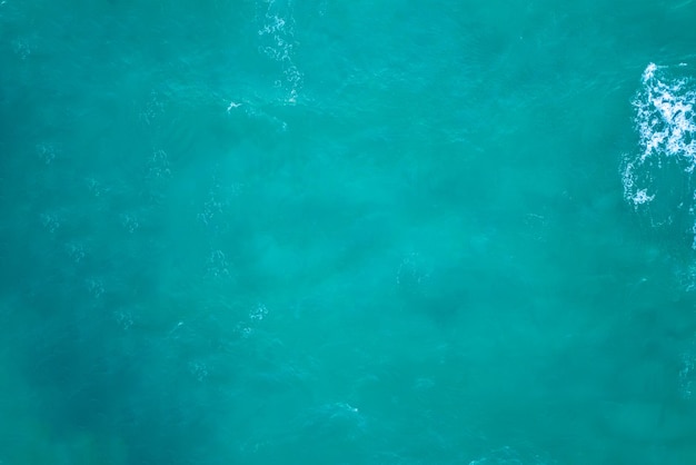 A blue sea water background with a white wave