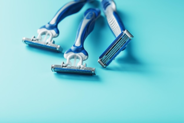 Blue shaving machines in a row on a blue background with ice cubes