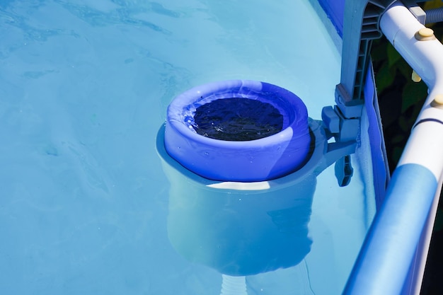 The blue skimmer for cleaning the pool in clear water Closeup of the skimmer mounted on a frame pool Control filtration system